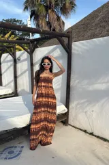 Vestido strapless largo con estampado batik en tonos marrones y beige, entallado al cuerpo y con espalda baja descubierta.