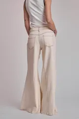 Pantalón de jean color crudo, corte palazzo con godets y costuras a contratono.