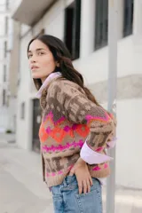 Saco corto tejido a mano con jaquard, cuello a la base y botones en la delantera.