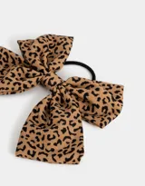 Gomita de pelo elástica con moño grande estampado animal print.