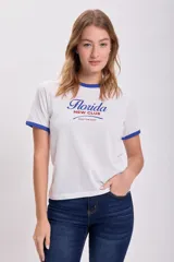 Remera blanca de algodón con cuello y mangas con ribete azul. Estampa frontal con la palabra "Florida" en azul y "New Club" en rojo.