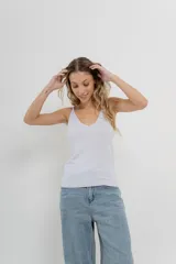 Musculosa amarilla de hilo con brillo sutil, de calce ajustado y breteles finos.