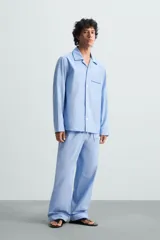 Pantalón de pijama celeste de algodón, corte relaxed fit, con cintura elástica ajustable con cordón interior, bolsillos laterales y detalle de vivos combinados a contraste en el bajo.