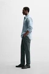 Pantalón de jean azul oscuro, corte slim fit, tiro medio, cinco bolsillos, tejido elástico y efecto lavado.