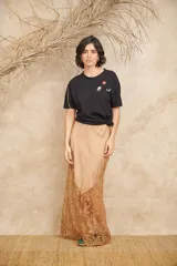 Pollera larga color rosa pálido, de tela satinada con encaje bordado en el ruedo.