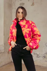 Campera puffer estampada con flores color naranja sobre fondo fucsia, de corte corto y cuello alto.