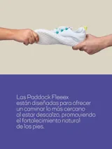 Zapatilla ergonómica blanca inspirada en el calzado barefoot, con suela fina, plana y flexible, y tira ajustable de velcro.