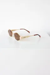 Lentes de sol con armazón y patillas metálicas plateadas, cristales oscuros con forma hexagonal facetada. La marca "AIRE" está grabada en la patilla derecha.