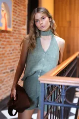 Blusa sin mangas color negro con hilo de lurex plateado, escote en V con botones frontales y choker atado en la espalda.