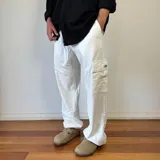 Pantalón cargo blanco de lino, corte oversize, con bolsillos laterales y cordón ajustable en la cintura.