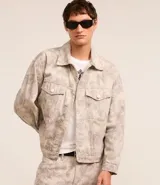 Campera masculina de sarga con estampa abstracta, corte boxy, cuello inglés, manga larga con puños abotonados, cierre frontal abotonado y bolsillos delanteros.