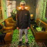 Campera negra tipo windbreaker con capucha, cierre frontal y puños elásticos. Logo de Kaboa en el pecho y estampado con el logo de Jägermeister en la manga.