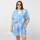 Conjunto de camisa de manga corta con cuello y short con cintura elástica, ambos con estampado de motivos marinos en blanco sobre fondo celeste.