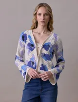 Cárdigan tejido calado color beige con estampado floral en tonos de azul y lila. Escote en V y cierre frontal con lazo.