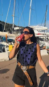 Remera corta de tafeta color verde militar con lunares de terciopelo negros, corte a la base y botón en la parte trasera.