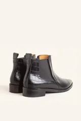 Bota tipo Chelsea de cuero vacuno con textura de efecto croco en color marrón oscuro. Presenta paneles elásticos laterales y una tira de ajuste en la parte posterior, con un taco bajo cuadrado.