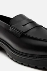 Mocasín de vestir negro con antifaz, forro y plantilla interior a tono y suela track.
