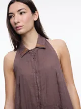 Vestido largo sin mangas confeccionado en lino, color azul, con cuello camisero y espalda descubierta con ajuste regulable.