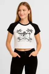 Remera corta blanca con mangas raglán negras y estampado frontal con palmeras y texto 'Palma Art Cultural'.