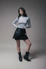 Minifalda negra cruzada con lazo lateral y estampado de una rosa blanca.