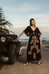 Poncho largo negro de lino con bordados multicolores de estilo azteca y flecos en las mangas.