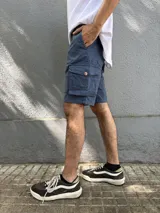 Bermuda de gabardina color marrón claro, corte recto, con bolsillos cargo laterales y bolsillos traseros con solapa.