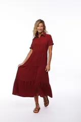 Vestido midi color borgoña, con cuello camisero, manga corta y falda escalonada.