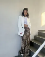 Blazer blanco con solapas de muesca, cierre cruzado con dos botones, bolsillos delanteros con solapa y corte recto.