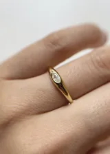 Anillo dorado con una zirconia incrustada en forma de ojo.