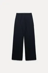Pantalón ancho gris con textura de espiga, tiro alto, doble cintura elástica ajustable con cordón, pinzas frontales, bolsillos delanteros y falso bolsillo de vivo en la espalda.