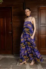 Vestido largo negro con transparencias y estampado floral. Tiene breteles finos, corte amplio y forro corto. Incluye bolsillos laterales.