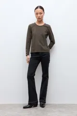 Remera de manga larga color verde oliva, con cuello redondo y botones decorativos en los puños.