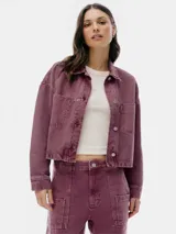 Chaqueta corta de denim color borgoña con cuello clásico, cierre frontal con botones metálicos y bolsillos de parche en el pecho.