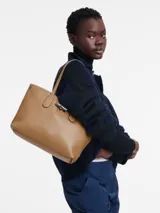 Cartera de cuero flexible color mostaza de Longchamp, con diseño elegante y asas largas.
