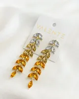 Par de caravanas colgantes con forma de hojas en tonos dorados y plateados.