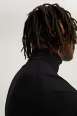 Jersey negro de punto fino con cuello alto y manga larga.