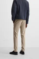 Pantalón chino azul marino, corte skinny fit, confeccionado en tejido de algodón con elasticidad. Cuenta con bolsillos frontales y traseros de vivo. Cierre frontal con cremallera y botón.