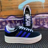 Championes Adidas Gazelle Bold, color negro con detalles en azul y suela de plataforma blanca.