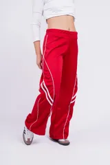 Pantalón deportivo rojo con detalles de líneas blancas curvas en los laterales.
