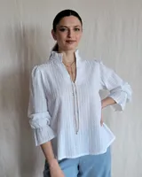 Blusa celeste con cuello mao y mangas abullonadas.