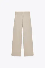 Pantalón de algodón color beige, de corte amplio y tiro alto, con cintura elástica ajustable con cordones y bolsillos laterales.