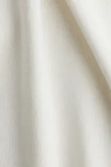 Musculosa de punto fino color blanco, entallada con escote en U adelante y atrás.