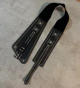 Cinturón faja de cuero sintético negro con elástico y tachas plateadas.