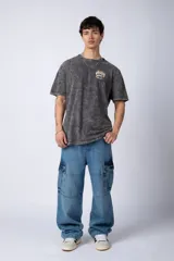 Remera gris con efecto acid wash, corte holgado y estampa frontal con una mano sosteniendo el mundo VCP.