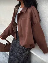 Bomber jacket color marrón de gamuza sintética, con cuello camisero, hombros caídos y elástico en la cintura.