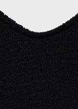 Traje de baño entero negro con textura y tirantes finos.