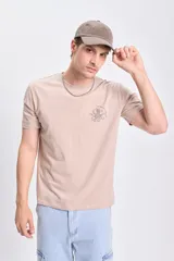 Remera color taupe de manga corta con estampa de un pulpo y texto en el pecho.
