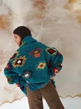 Saco de lana marrón con diseño geométrico multicolor, cuello con solapa, cierre frontal con botones y bolsillos delanteros.