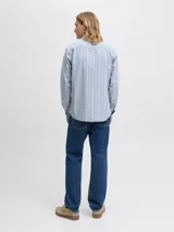 Camisa de vestir celeste a rayas verticales blancas, de manga larga y cuello abotonado. Corte slim fit.