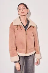 Abrigo oversize color camel, con forro de felpa y detalles de cierre frontal.